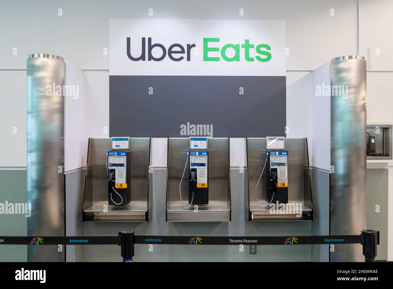 Uber mangia la pubblicità in cima ai telefoni pubblici a pagamento in Pearson International Airport a Toronto City, Canada, anno 2021 Foto Stock