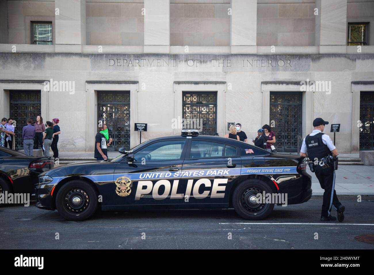 Washington, Stati Uniti. 14 Ott 2021. L'ufficiale di polizia si alza in guardia da un'auto durante la dimostrazione. Attivisti ambientali arrestati dopo aver occupato il Bureau of Indian Affairs presso il Department of Interior. (Foto di Karla Cote/SOPA Images/Sipa USA) Credit: Sipa USA/Alamy Live News Foto Stock