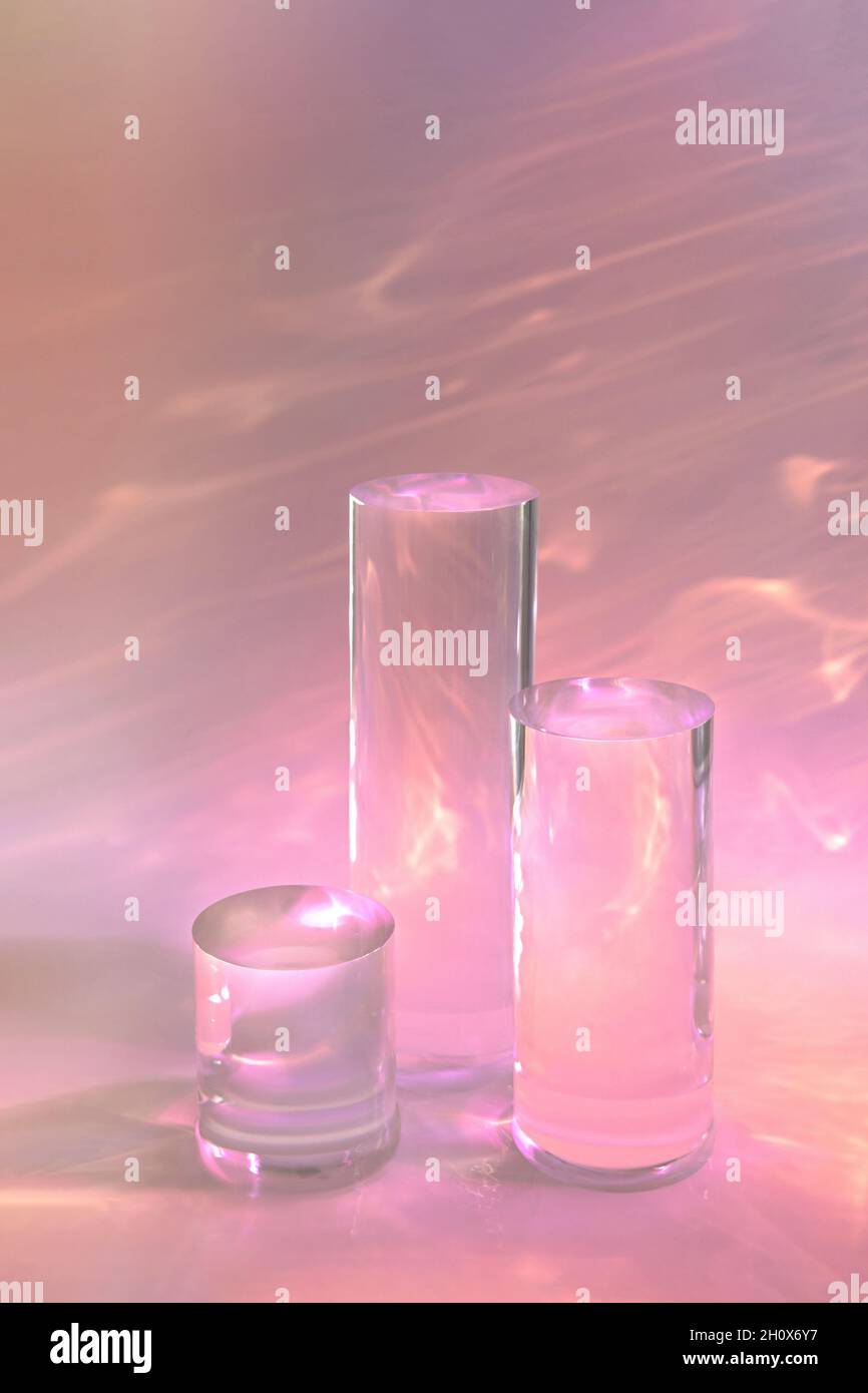 tre podi in vetro chiaro su sfondo rosa pastello Foto Stock