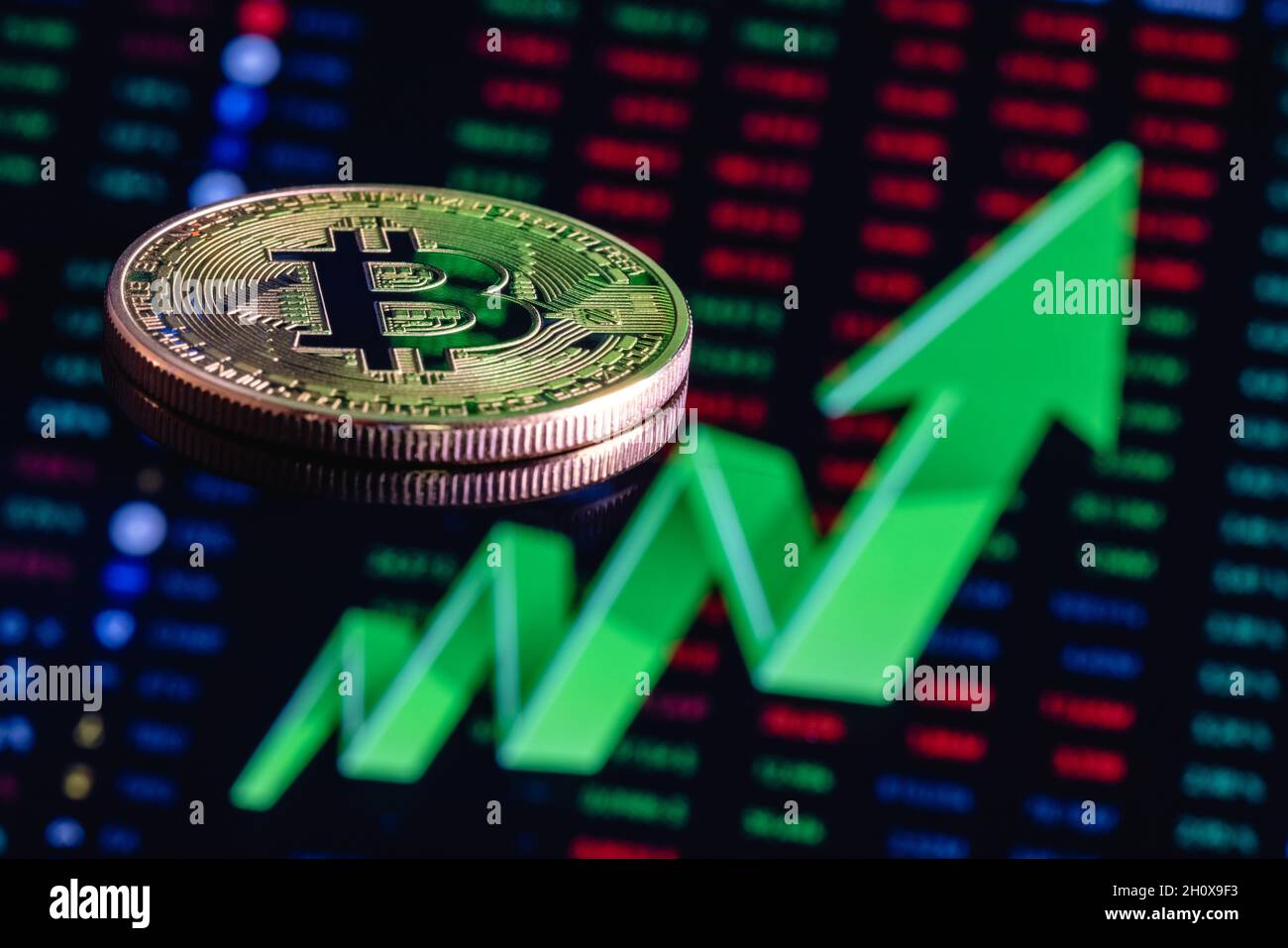 Bitcoin sullo sfondo di una grande freccia verde rivolta verso l'alto. Il concetto di crescita del tasso di cambio Bitcoin. Foto Stock