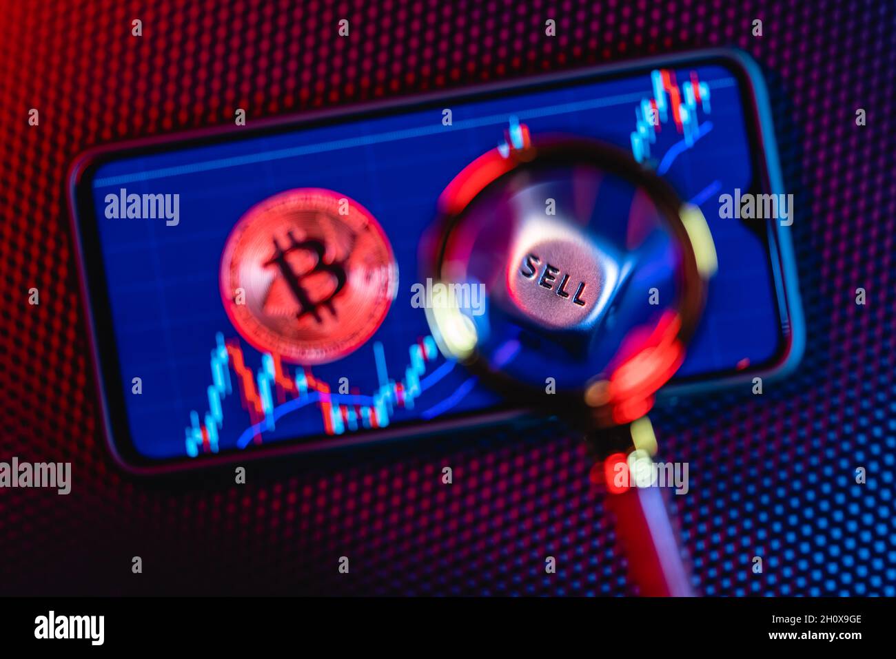 Bitcoin sullo sfondo di uno schermo dello smartphone con l'immagine di candele di scorta. Foto Stock