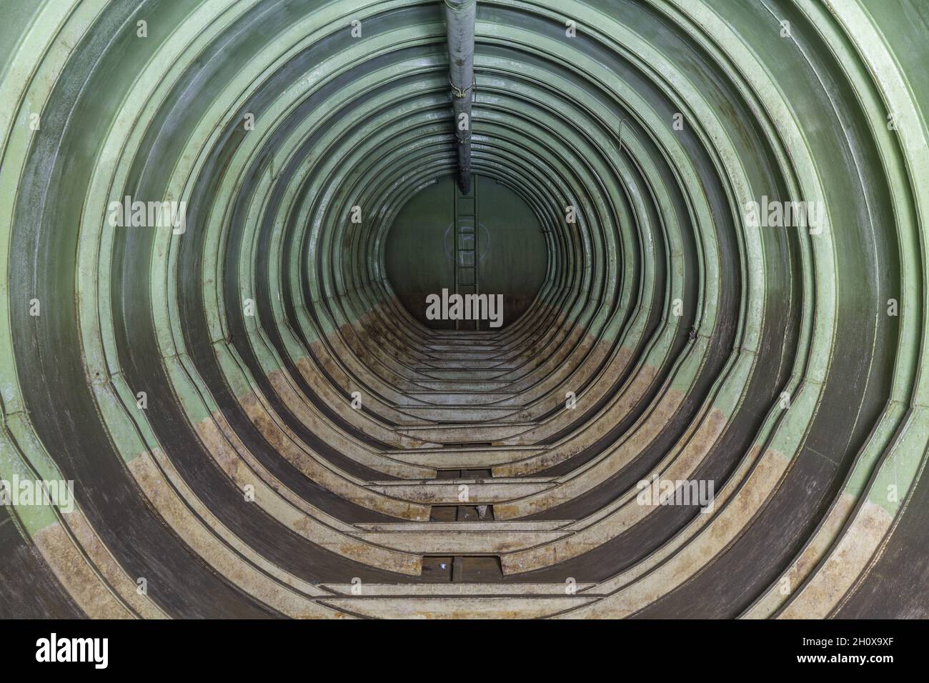 Resti del deposito sotterraneo dell'esercito sovietico a Rabštejn-Janská, in Czechia. Interno di un serbatoio carburante lungo, con una scala all'estremità Foto Stock