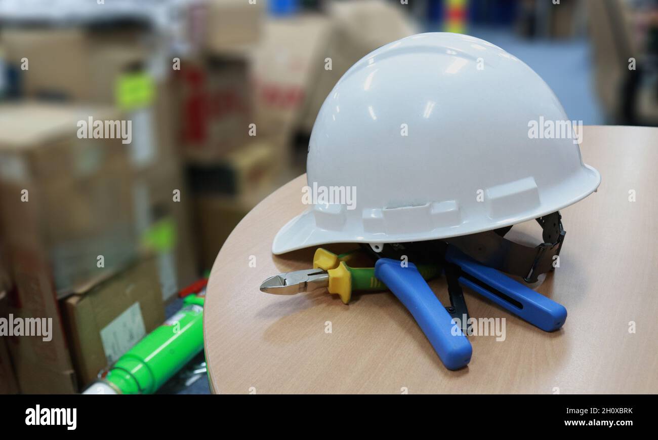 Un casco di sicurezza bianco per proteggere la testa dei lavoratori da incidenti sul lavoro, come ad esempio collisioni con oggetti duri, i caschi sono un requisito di sicurezza prima di tutto Foto Stock