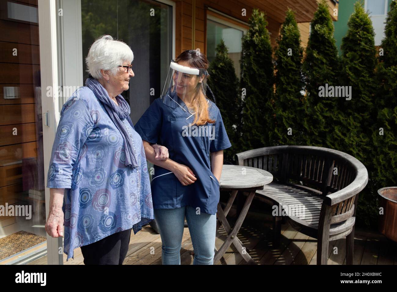 Infermiera che cammina con donna anziana Foto Stock