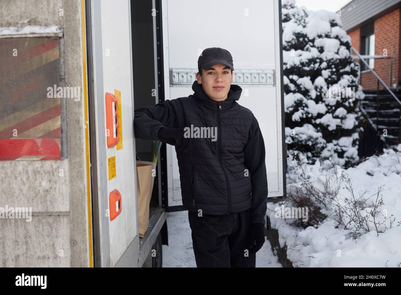 Corriere in piedi vicino al camion Foto Stock