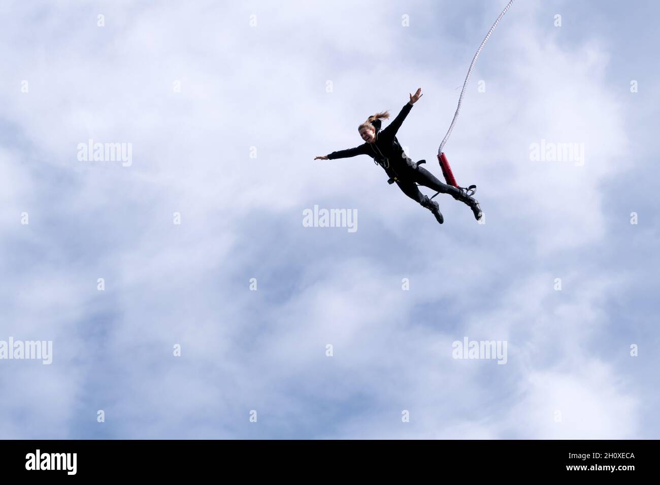 Bungy jumper saltare da un ponte alto sopra il vuoto e giù per il profondo mare nord Foto Stock