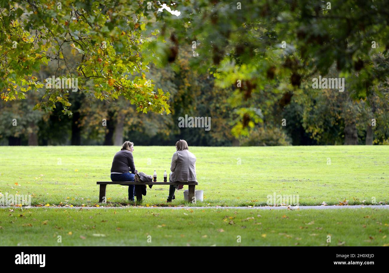 Londra, Inghilterra, Regno Unito. Regent's Park: Due donne che parlano su una panchina Foto Stock