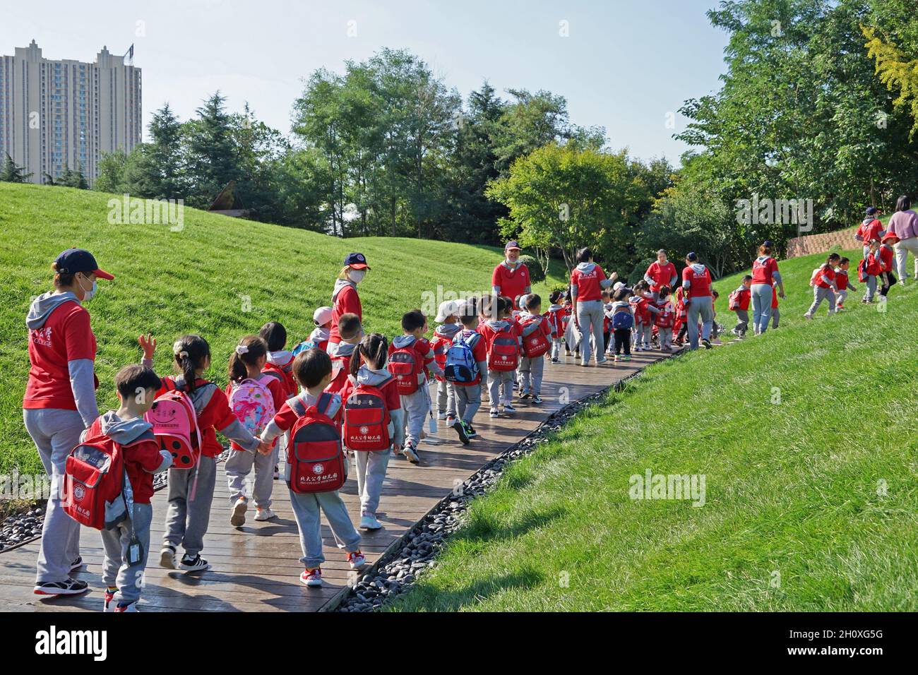 Yantai, Yantai, Cina. 15 ottobre 2021. Il 12 ottobre 2021, un gruppo di bambini nella città di Yantai, provincia di Shandong, guidati da un insegnante di asilo.secondo i calcoli della ''Nuova conoscenza della Finanza e dell'Economia'', nel primo semestre del 2021 la popolazione natale nazionale diminuirà di circa il 16% rispetto allo stesso periodo dell'anno scorso. Utilizzando questo tasso di cambiamento per estrapolare i dati annuali, la popolazione di nascita del nationÃ¢â‚¬â„¢potrebbe scendere a circa 9.98 milioni quest'anno. Il punto di svolta storico della crescita negativa della popolazione è molto probabile che arriverà quest'anno. Secondo lo statista Foto Stock