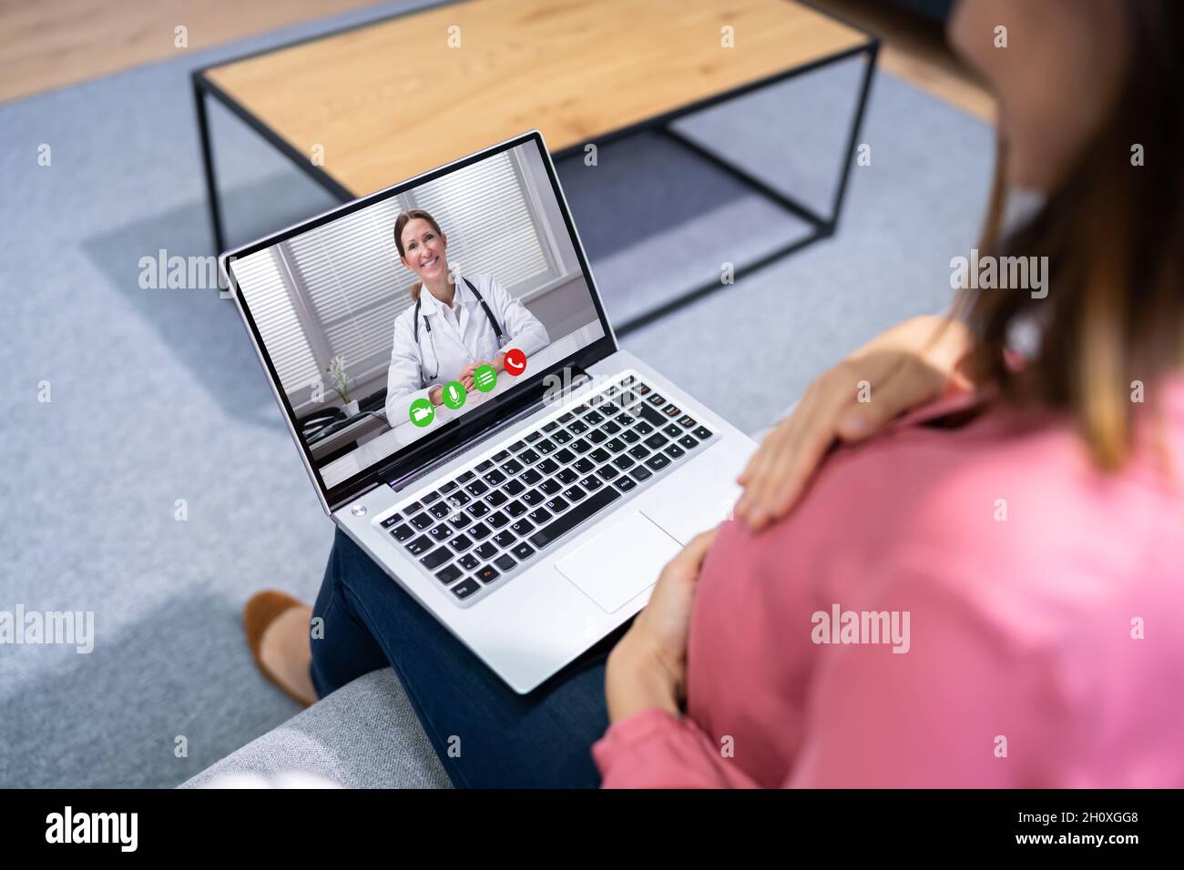 Donne incinte medico videochiamata sul portatile a casa Foto Stock