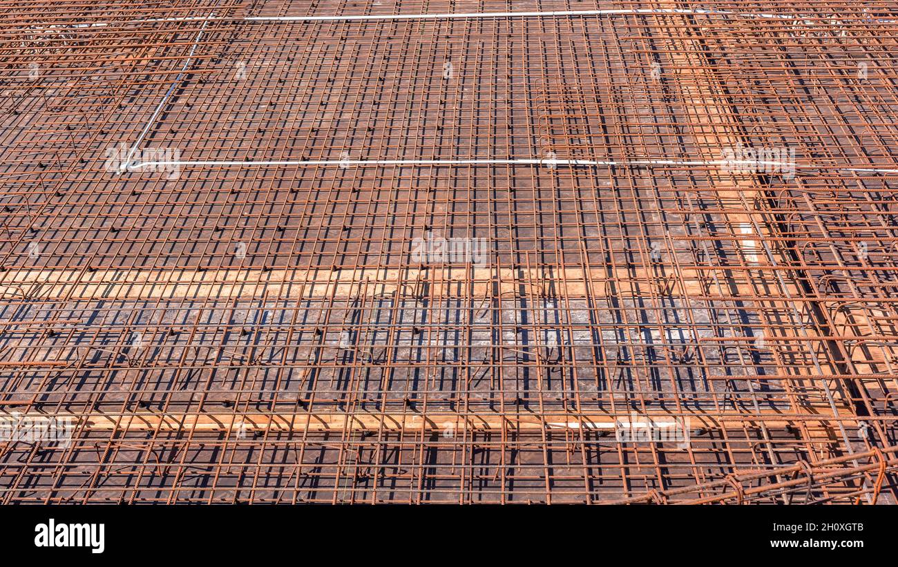Costruzione aste industriali in acciaio struttura legata a filo primo piano per calcestruzzo cemento versato su pavimento piattaforma esterna edificio. Foto Stock