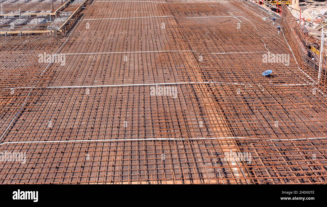 Costruzione aste industriali in acciaio struttura legata a filo primo piano per calcestruzzo cemento versato su pavimento piattaforma esterna edificio. Foto Stock