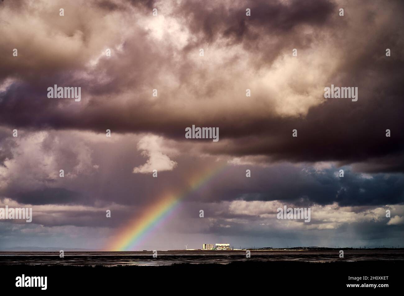 Rainbow sopra la centrale nucleare di Heysham nel giorno tempestoso sopra Morecambe Bay Foto Stock