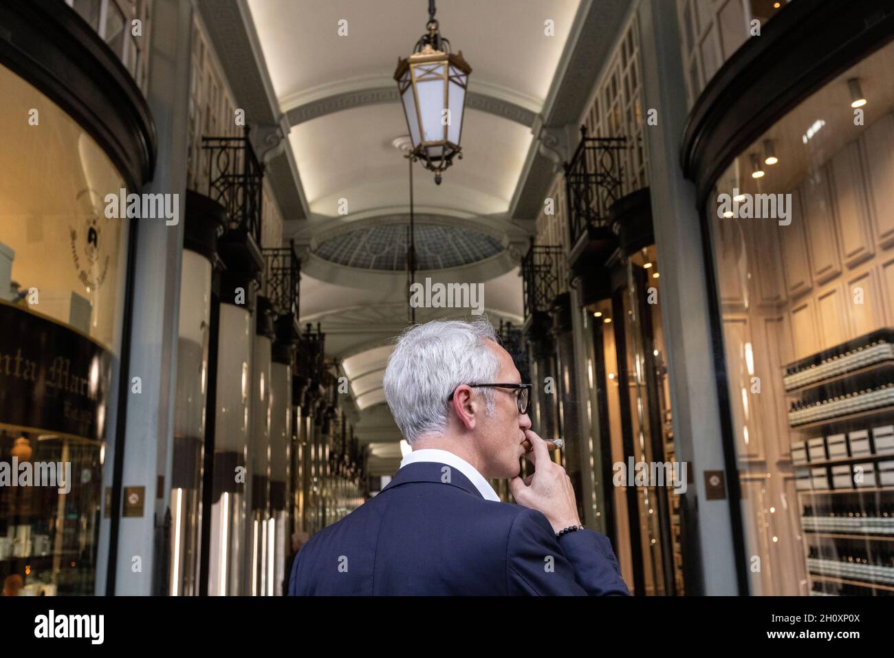 Uomo che fuma un sigaro all'ingresso di Piccadilly Arcade, Londra, Inghilterra, Regno Unito Foto Stock