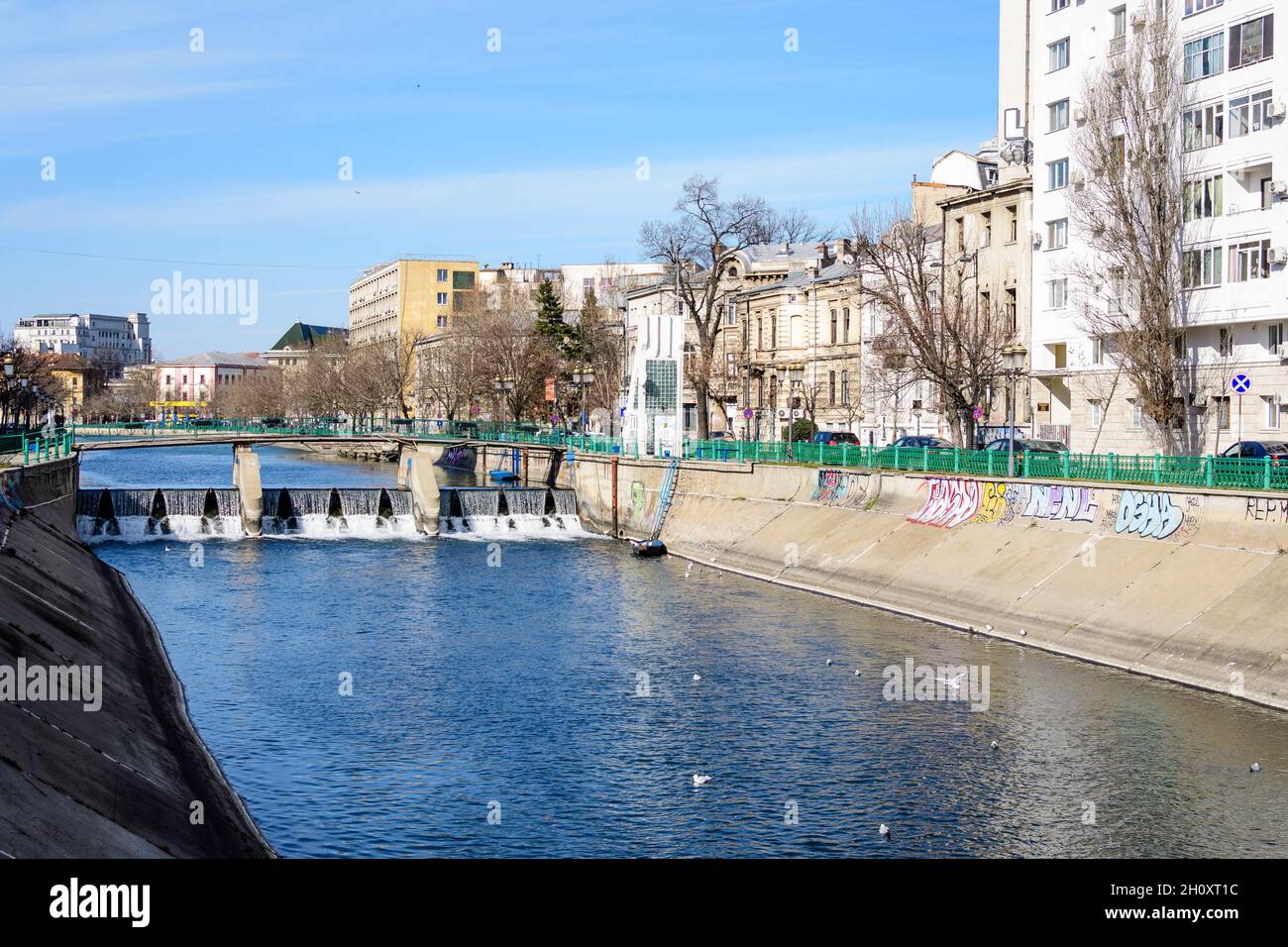 Bucarest, Romania, 13 Febbraio 2021 - Ponte piccolo, vecchi edifici vicino al fiume Dambovita e cielo azzurro nel centro di Bucarest, Romania, in a s Foto Stock