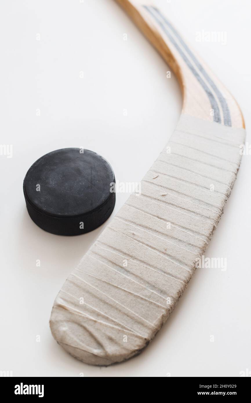 Riavvolgere il bastone da hockey e il disco nero da hockey su sfondo bianco Foto Stock