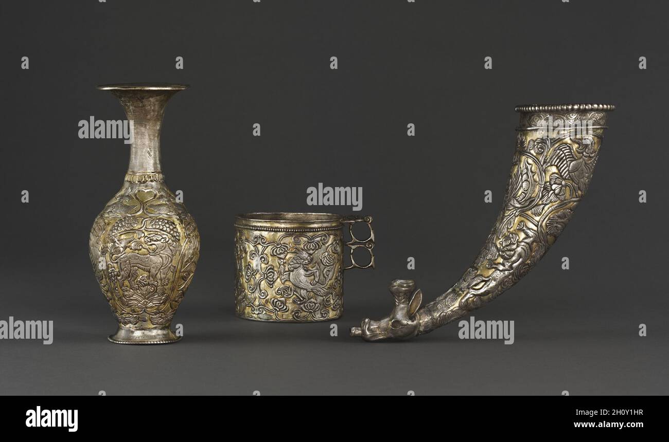 Vasi d'argento, c.. 700. Asia centrale o Tibet, inizio VIII secolo. Argento con doratura; totale: 22.9 cm. Queste navi attestano il clima internazionale che pervadeva le regioni di Cina, Tibet e Asia centrale durante il periodo della dinastia espansionista Tang (618-907). È ornata prevalentemente con elementi dell'Asia centrale, tra cui viti, bordi con perline e motivi a forma di cuore. È noto che gli artigiani sogdiani si sono specializzati nella tecnica di compensazione del disegno repoussé d'argento con lamina dorata. La forma del rhyton capo animale come un vaso da bere e noi Foto Stock