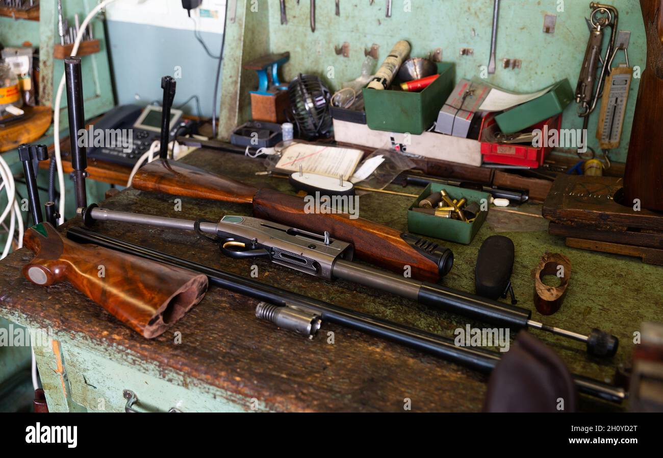 Fucile automatico smontato sul tavolo dell'officina armi Foto Stock