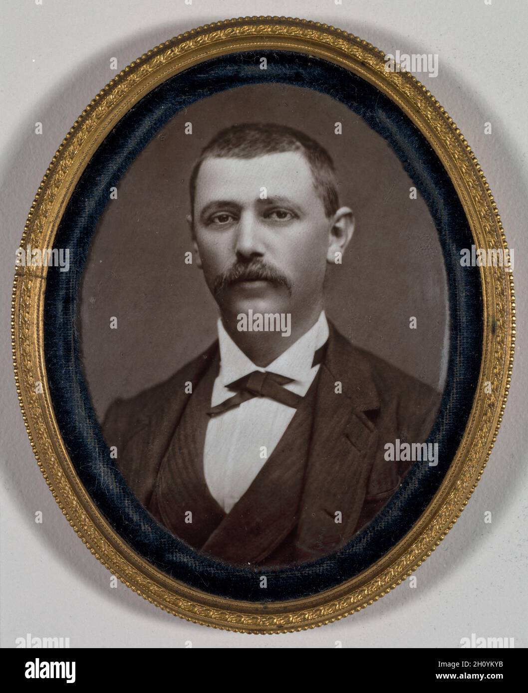 Untitled (Ritratto di un uomo), 1879. Etienne Carjat (francese, 1828-1906). Fotografia su smalto in lega di rame con rivestimento in velluto; totale: 7.7 x 6.2 cm (3 1/16 x 2 7/16 poll.). Il celebre fotografo parigino Etienne Carjat stabilì la sua reputazione attraverso la ritrattistica delle celebrità, ma il suo punto di forza era l'immagine di un gruppo di persone della classe media e superiore come questa coppia, presumibilmente marito e moglie. Cercando immagini più permanenti di quelle fatte su carta, hanno pagato extra per avere i loro ritratti vetrificati su smalto. Il processo consente di ottenere immagini estremamente dettagliate e durature che appaiono fresche come Foto Stock