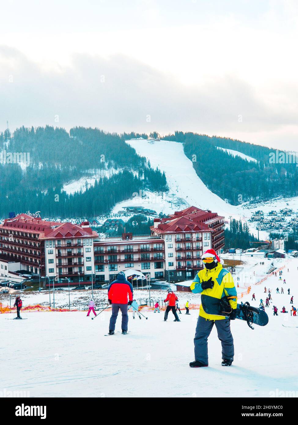 uomo con snowboard in cappello rosso di natale che cammina neve collina  inverno montagna stazione sciistica Foto stock - Alamy