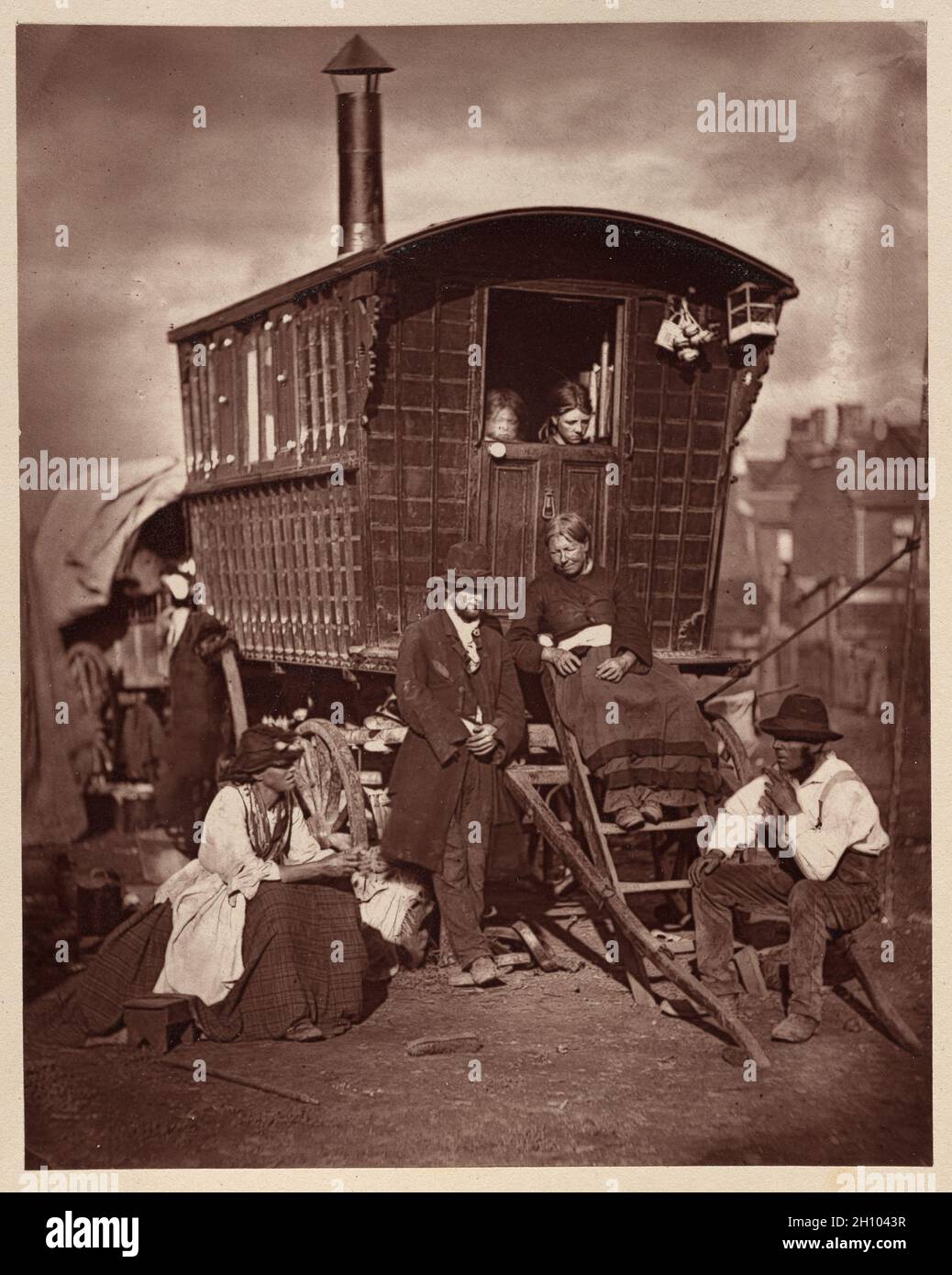Street Life a Londra: London Nomades, 1877. John Thomson (scozzese, 1837-1921). Woodburytype; immagine: 10.8 x 8.6 cm (4 1/4 x 3 3/8 poll.); carta: 10.8 x 8.6 cm (4 1/4 x 3 3/8 poll.); montata: 27.1 x 20.8 cm (10 11/16 x 8 3/16 poll.). “a Londra ci sono un certo numero di ciò che si può definire, a causa delle loro abitudini vaganti e instabili, tribù nomadi”, ha scritto Adolphe Smith, collaboratore di John Thomson. Vivendo nei carri, si sono spostati intorno alla città, lavorando i lavori stagionali o vendendo i prodotti poco costosi alle fiere ed ai mercati o porta a porta. Foto Stock