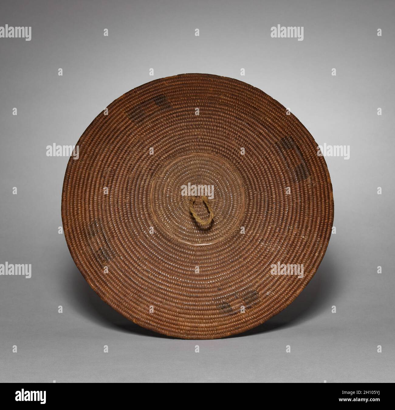 Coperchio per pentola, 1900. Africa meridionale, Sudafrica, Zulu, metà del XX secolo. Fibra vegetale; diametro: 45.7 cm (18 in.); totale: 33 cm (13 in.). Questa grande imbarcazione, di forma splendida, è stata utilizzata per servire la birra, una componente essenziale dell'ospitalità di Zulu. I vasi non decorati erano per uso domestico privato, ed esempi ornati erano riservati agli ospiti. La ceramica di Zulu è prodotta da donne, ed è tipicamente sottile-murata, con una superficie nera brunita. La decorazione può essere incisa intorno alla spalla, come in questo esempio, o può consistere in protuberanze rialzate che assomigliano alla scarificazione del corpo. Il cesti li Foto Stock