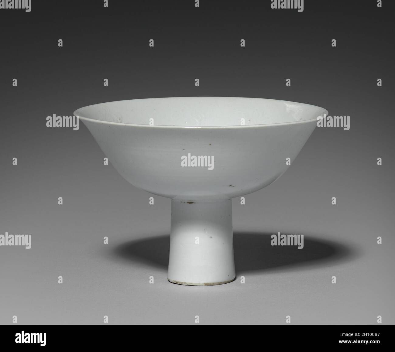 Stelo Cup con emblemi buddista: Shufu Ware, 1300s. Cina, provincia di Jiangxi, dinastia Yuan (1271-1368). Porcellana con decorazione plastica e smalto bianco; complessivo: 10,2 x 15,3 cm (4 x 6 in.). Foto Stock