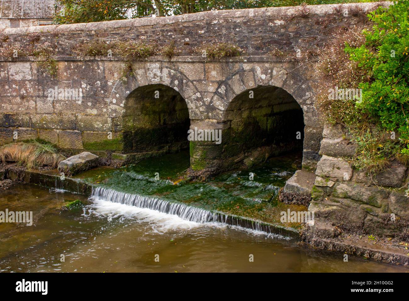 Ponte di pietra con due archi a Gweek un villaggio sul fiume Helford vicino Helston nella Cornovaglia sud Inghilterra Regno Unito Foto Stock