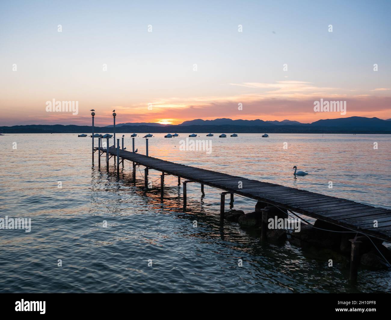 Molo del Lago di Garda o molo al tramonto in serata sulla penisola di Sirmione Foto Stock