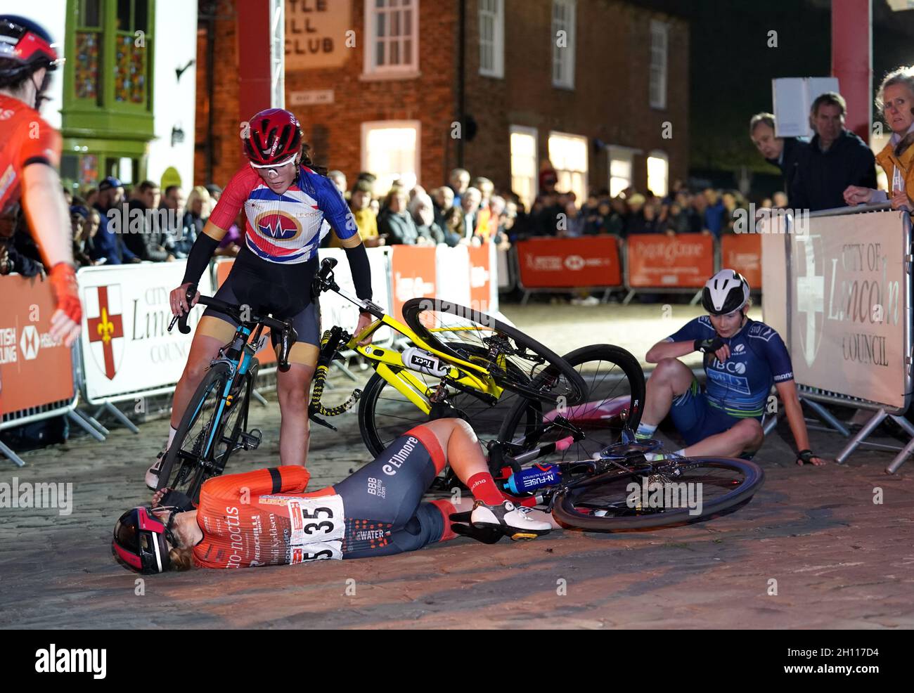 Beth Morrow of Story Racing aiuta dopo Corinne lato di Pro-Noctis - Redchili Bikes - Heidi Kjeldsen e Abi Smith del Team TIBCO-Silicon Valley Bank a scontrarsi vicino al traguardo durante il British Cycling National Championships Women's Circuit Race attraverso Lincoln. Data foto: Venerdì 15 ottobre 2021. Foto Stock