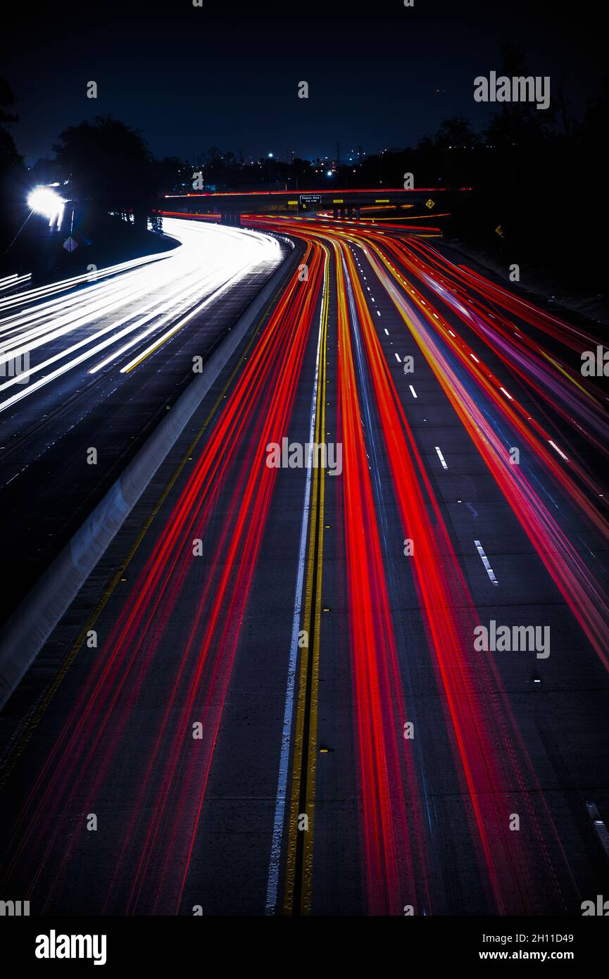 Ampia autostrada con astratto luminoso traffico sentieri di notte, sfondo verticale Foto Stock