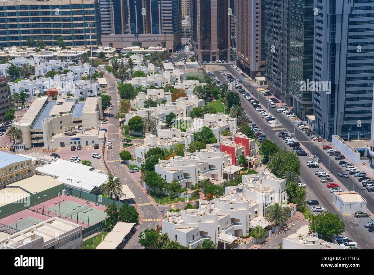Un'area residenziale di ville di lusso di Abu Dhabi vicino a Corniche, con moderni blocchi a torre sullo sfondo.UAE Foto Stock