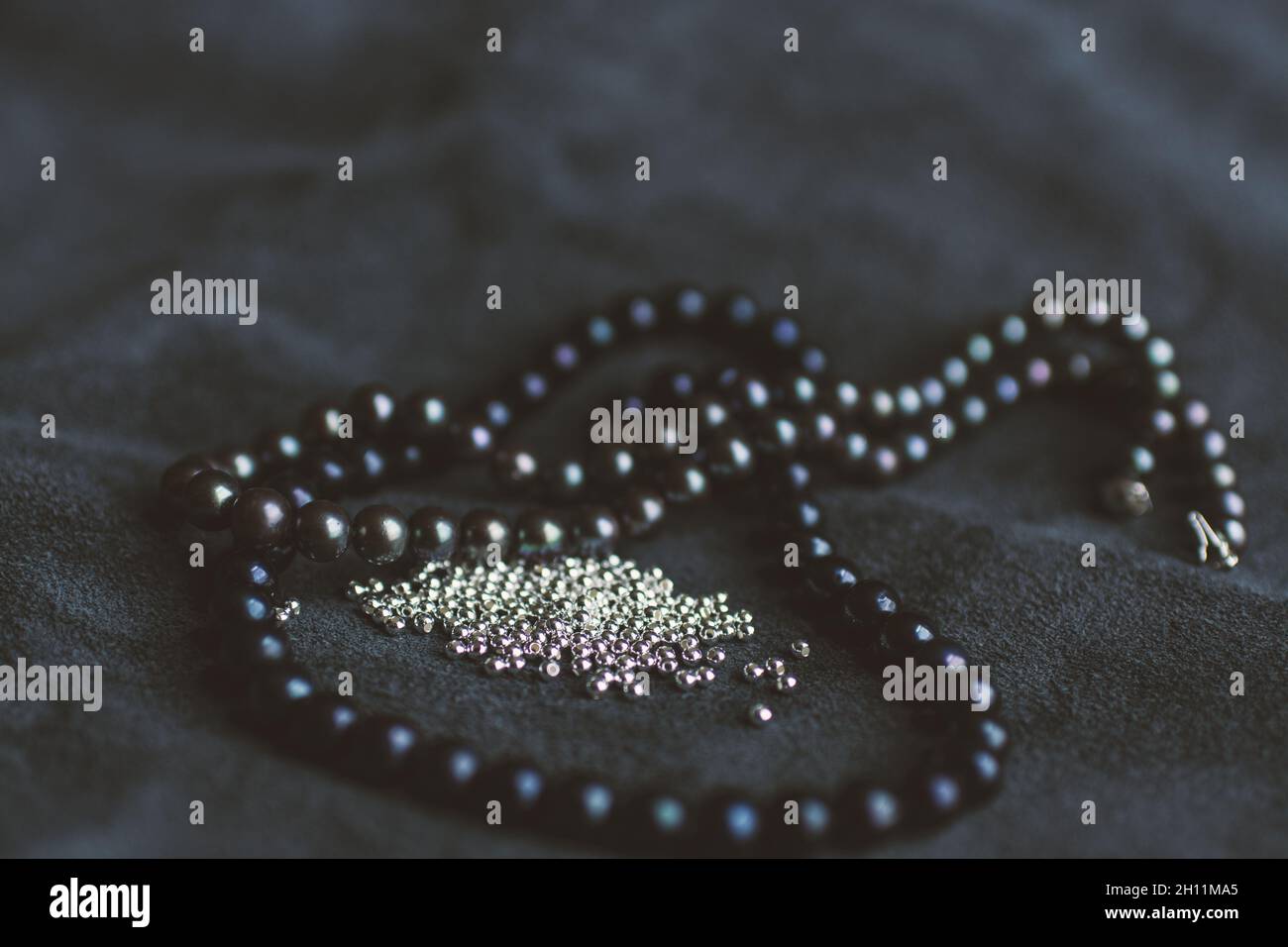 Stringa di perle nere e alcune perle d'argento sul cuoio Foto Stock