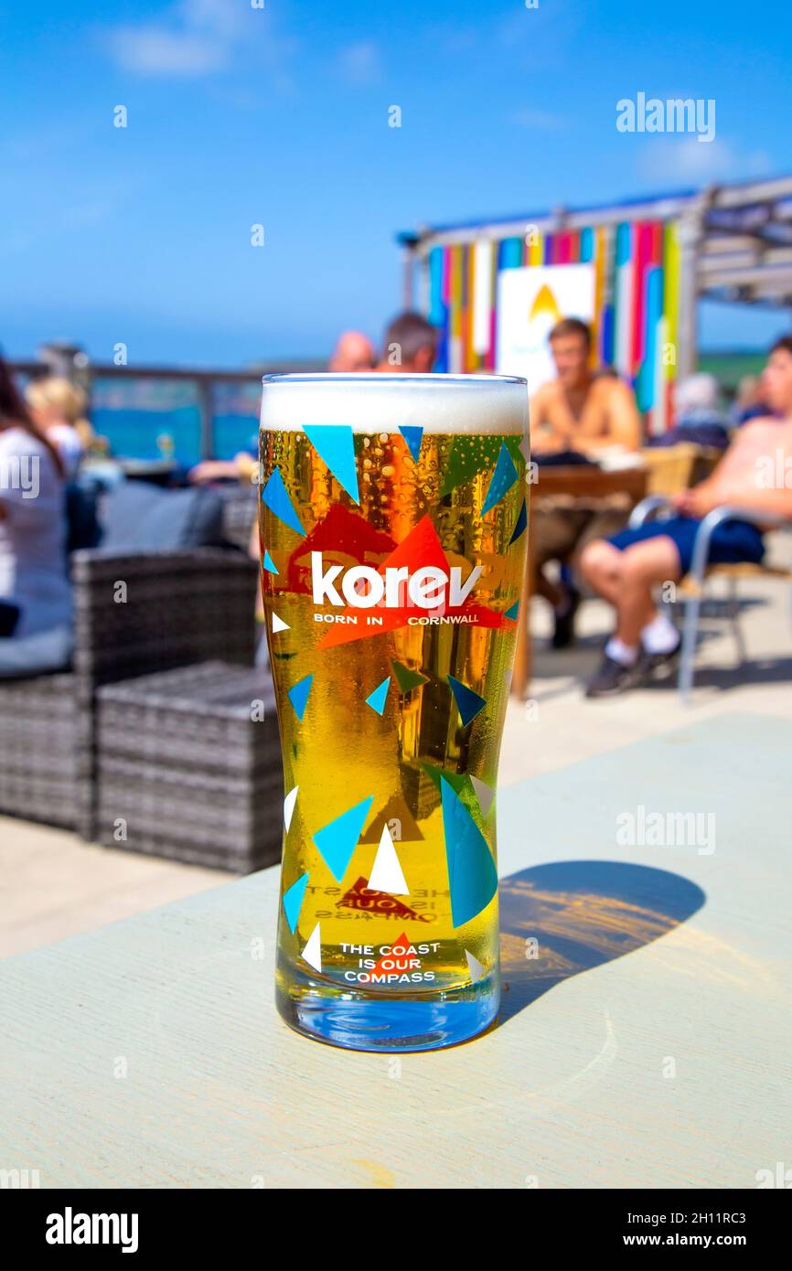 Korev Cornish birra in un bicchiere al Surf Beach Bar, Sennen Cove, Penwith Peninsula, Cornovaglia, Regno Unito Foto Stock