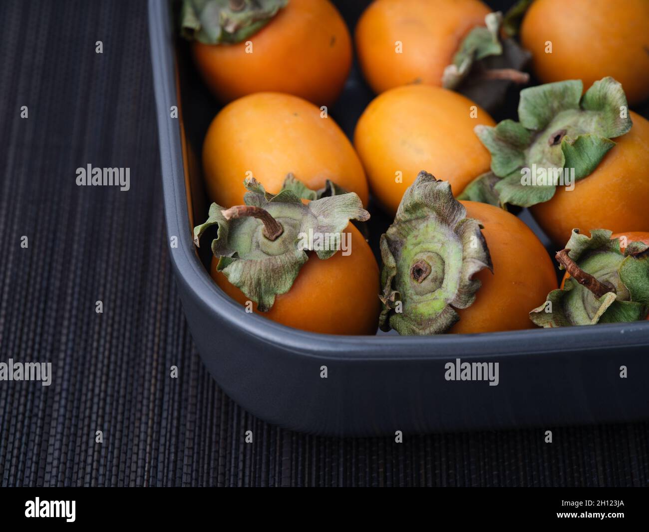 Persimmons in un vassoio tasto basso. Primo piano. Foto Stock