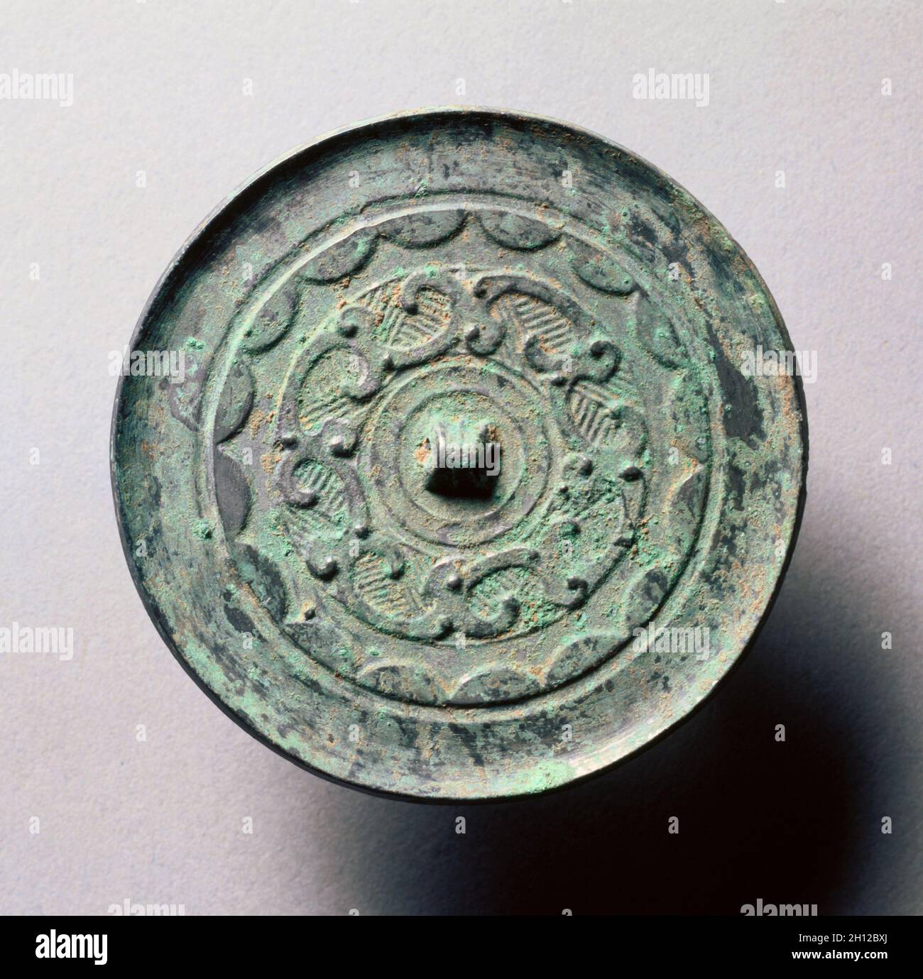 Specchio con archi continui e quasi-Dragoni, fine III secolo a.C.-i secolo. Cina, dinastia Han occidentale (202 AC-ad 9). Bronzo; diametro: 7.7 cm (1/16 in.); totale: 0.4 cm (3/16 in.); bordo: 0.2 cm (1/16 in.). Foto Stock