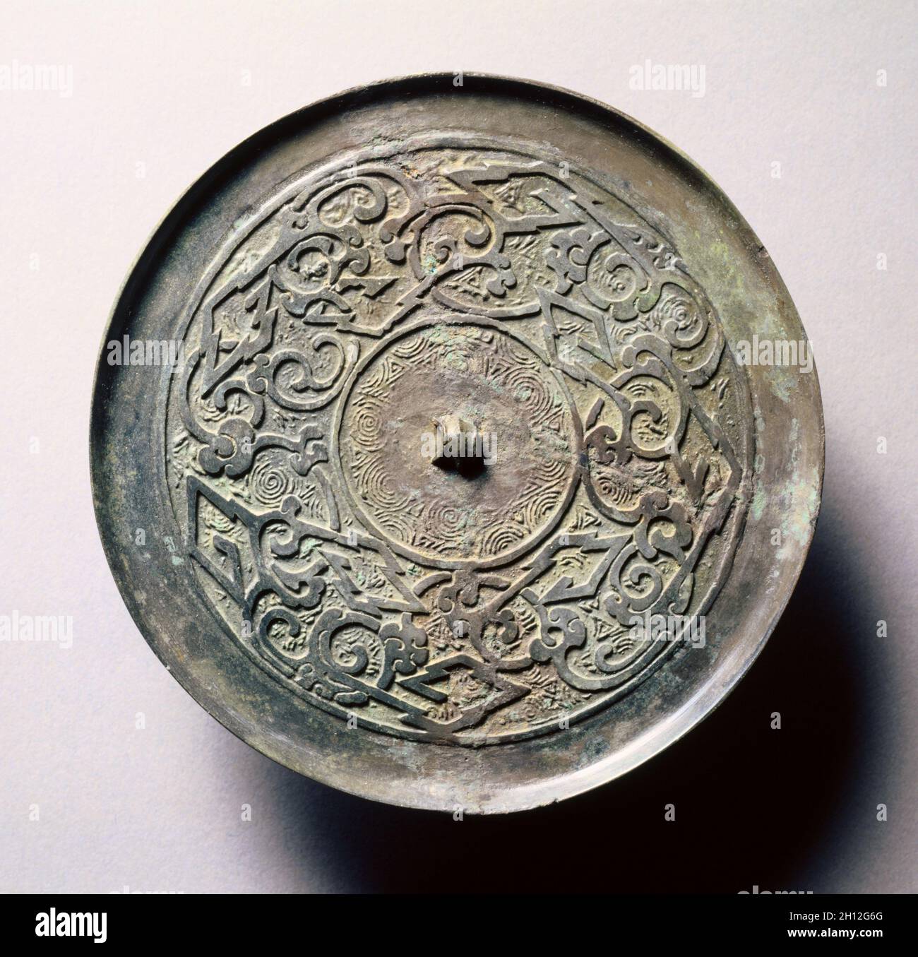 Specchio con intrecci a serpentina e meandri angolare, inizio 5th-fine del III secolo A.C. Cina, Est della dinastia Zhou (771-256 a.C.), periodo di Stati belligeranti (475-221 a.C.). Bronzo; diametro: 11,7 cm (4 5/8 in.); complessivo: 0,6 cm (1/4 in.); RIM: 0,5 cm (3/16 in.). Foto Stock