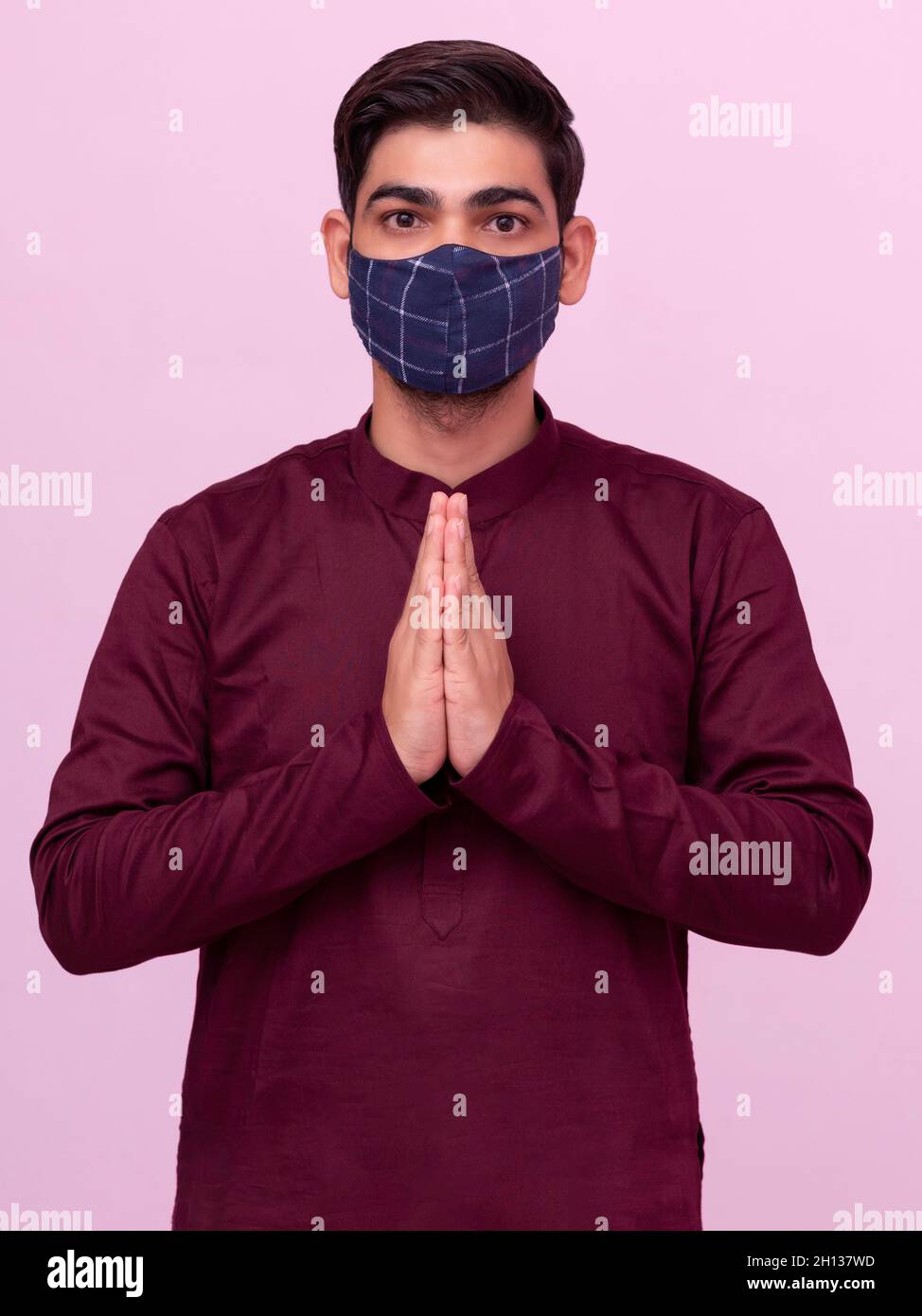 Uomo indiano namaste gesto con maschera. Foto Stock