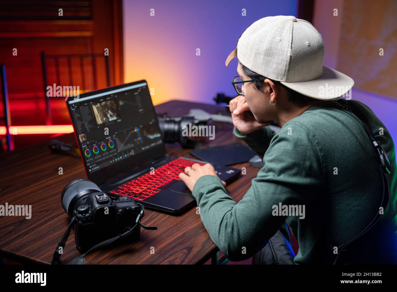 Un uomo realizza video editing. Realizzazione di film. Produzione video. Foto Stock