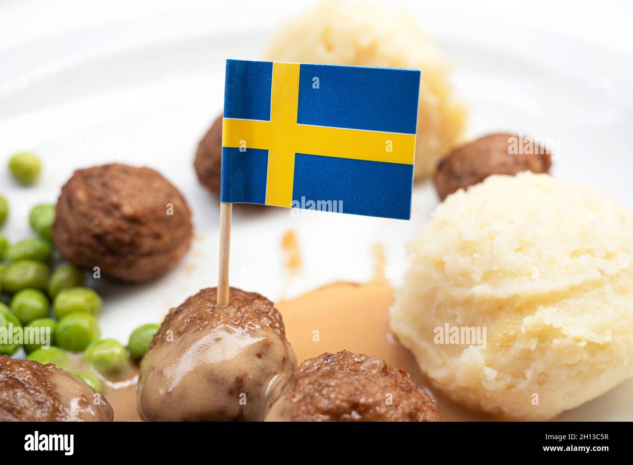 Polpette con patate bollite e salsa rossa dolce decorata con bandiera svedese - piatto tradizionale svedese Foto Stock