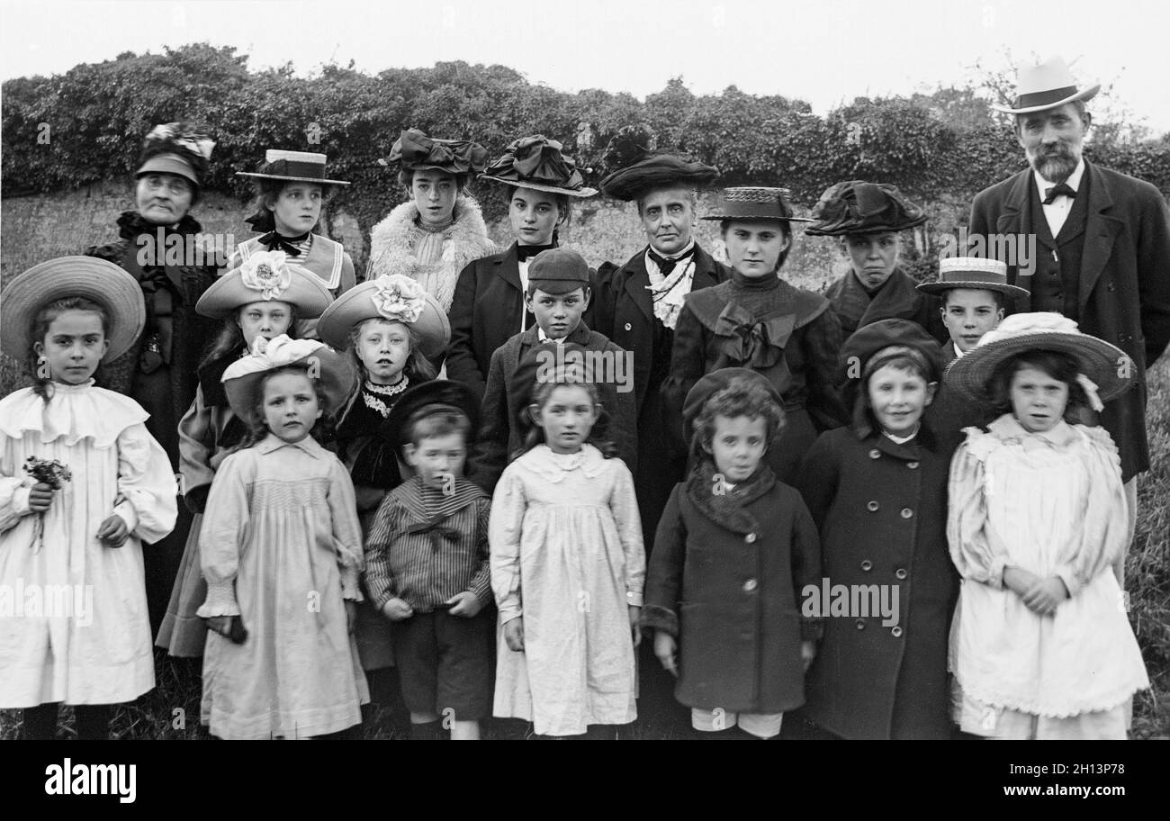 Una fotografia vittoriana inglese d'epoca che mostra un gruppo di famiglie di 19 persone di diverse età in posa per il fotografo. Le mode e gli stili dell'epoca sono visibili. Foto Stock