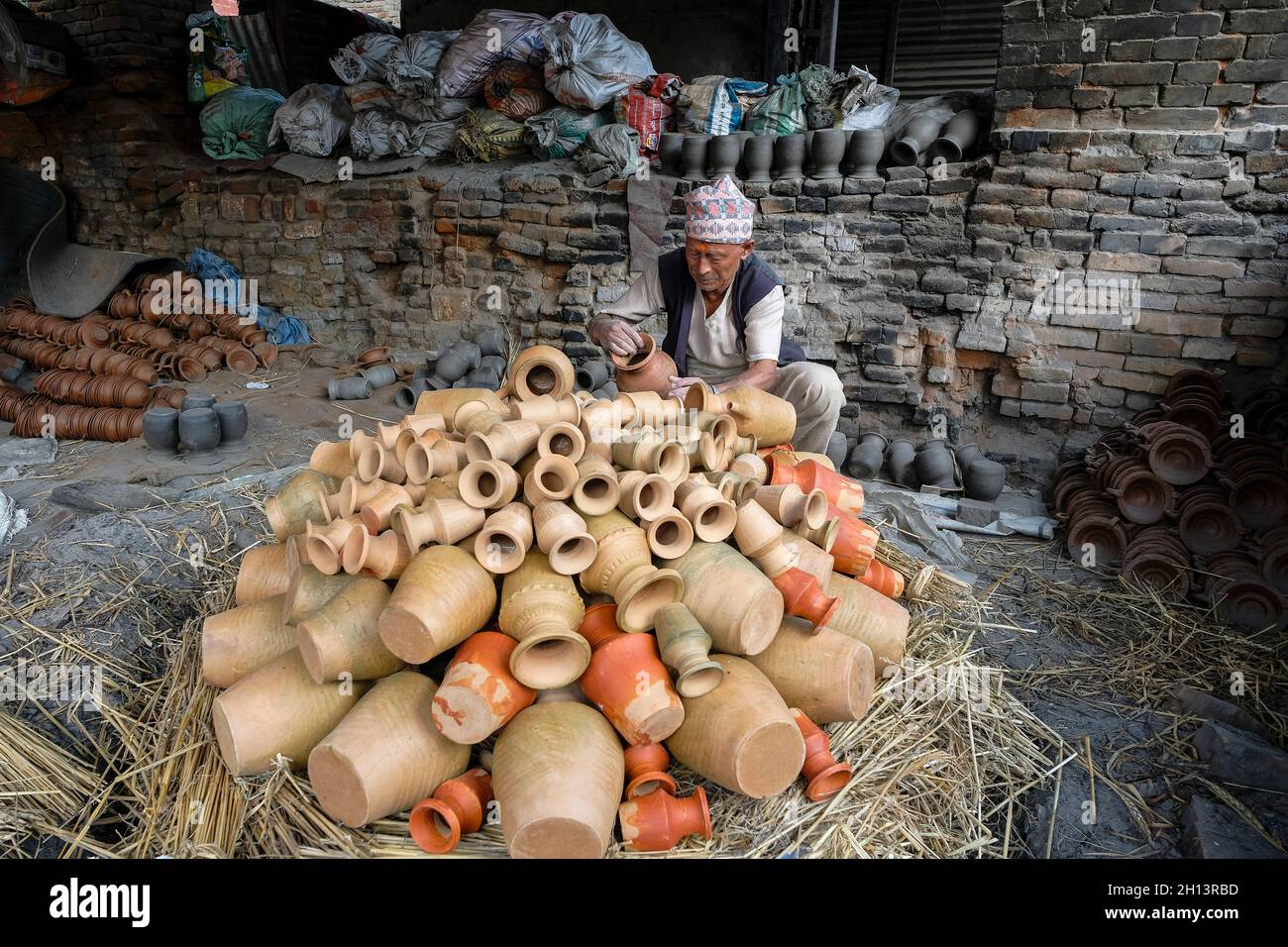 Bhaktapur, Nepal - Ottobre 2021: Un uomo che vende ceramiche in Piazza delle ceramiche a Bhaktapur il 10 Ottobre 2021 nella Valle di Kathmandu, Nepal. Foto Stock