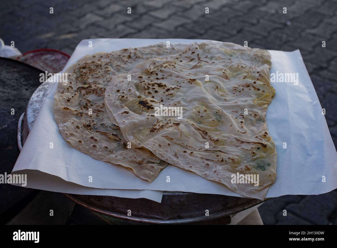 Tradizionale pane piatto turco (gozleme) con ripieno sul mercato contadino all'aperto. Street food Foto Stock