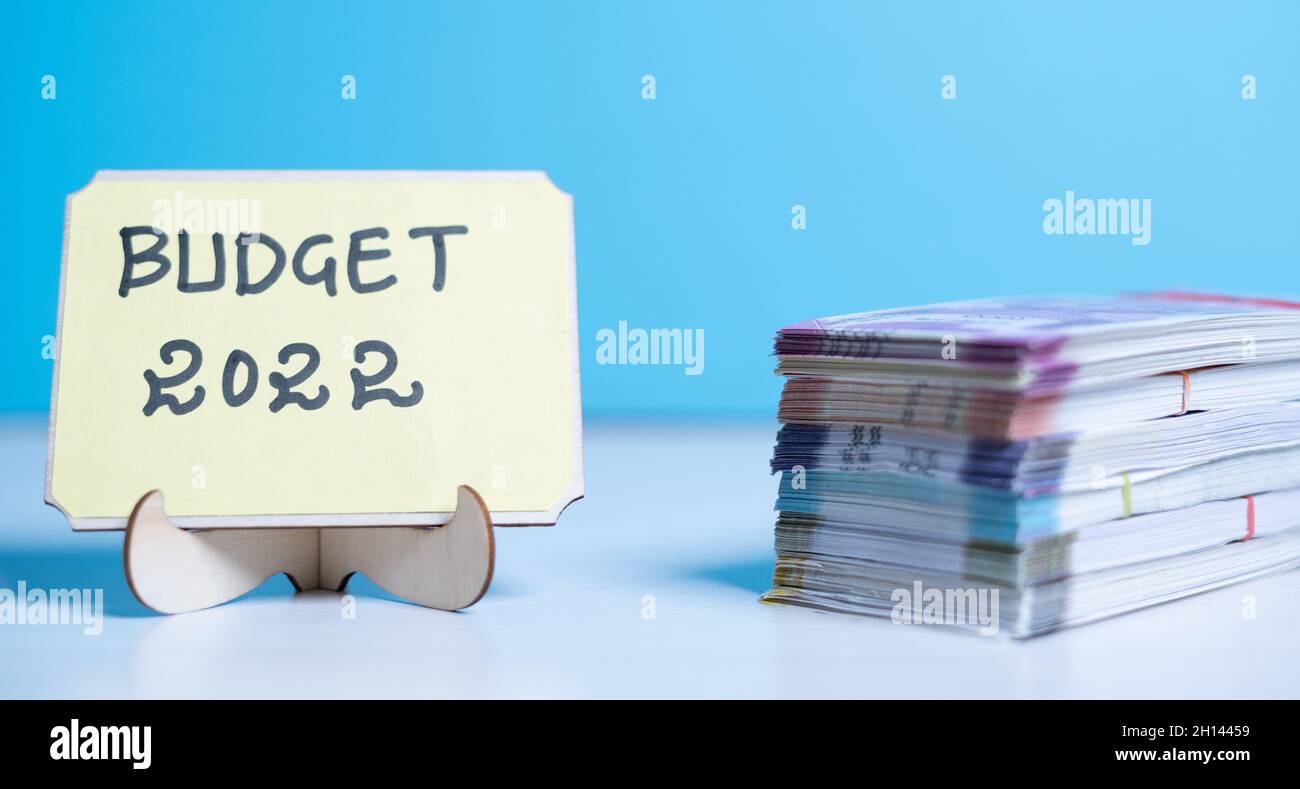 Concetto di pianificazione o di impostazione del bilancio per il nuovo anno 2022 che mostra per stack di banconote accanto al cartello bilancio 2022. Foto Stock