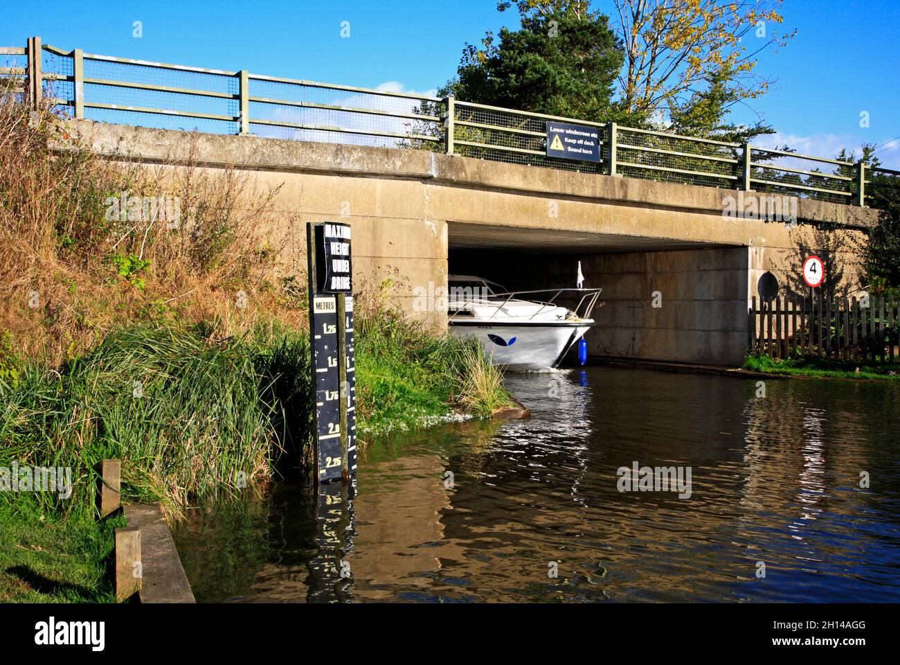 Un incrociatore sul fiume ANT sui Norfolk Broads passando sotto il ponte stradale A1062 a Ludham, Norfolk, Inghilterra, Regno Unito. Foto Stock