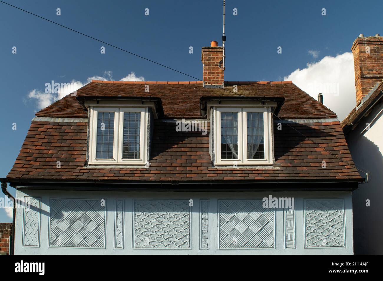 Primo piano le finestre moderne di prolungamento del tetto su casa blu con decorazioni sul muro a Saffron Walden, Inghilterra Foto Stock