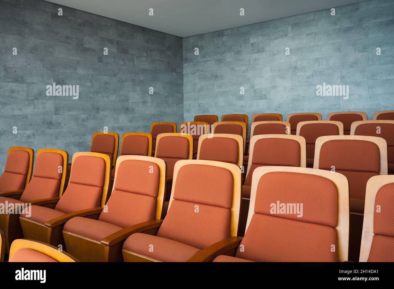 Fila di posti a sedere marroni per il teatro e muro di marmo nella sala dell'auditorium Foto Stock