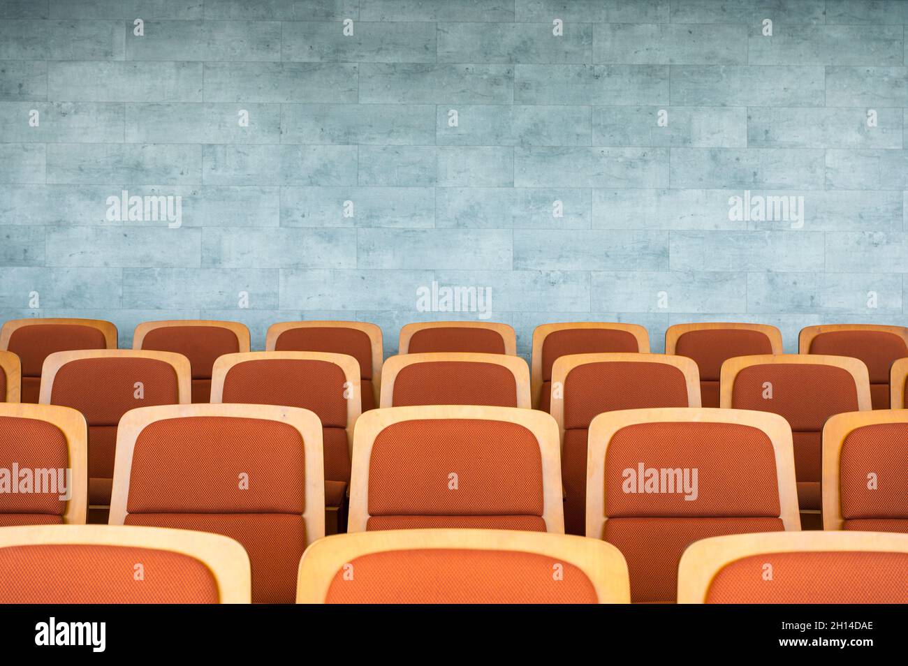 Fila di posti a sedere marroni per il teatro e muro di marmo nella sala dell'auditorium Foto Stock