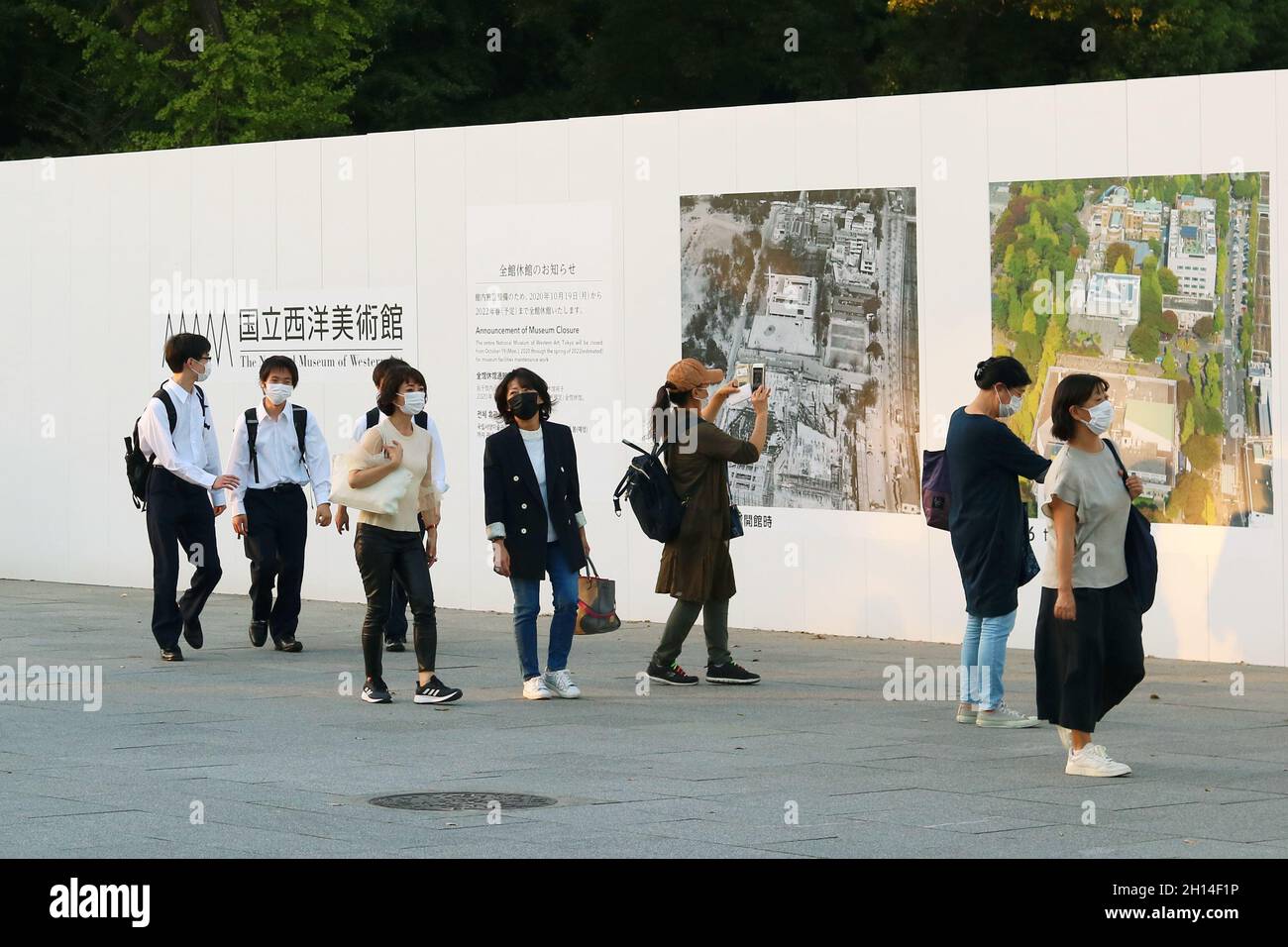 Persone nel Parco Ueno di Tokyo passando una recinzione di fronte al Museo Nazionale di Arte Occidentale temporaneamente chiuso per lavori di ristrutturazione (10/2021). Foto Stock
