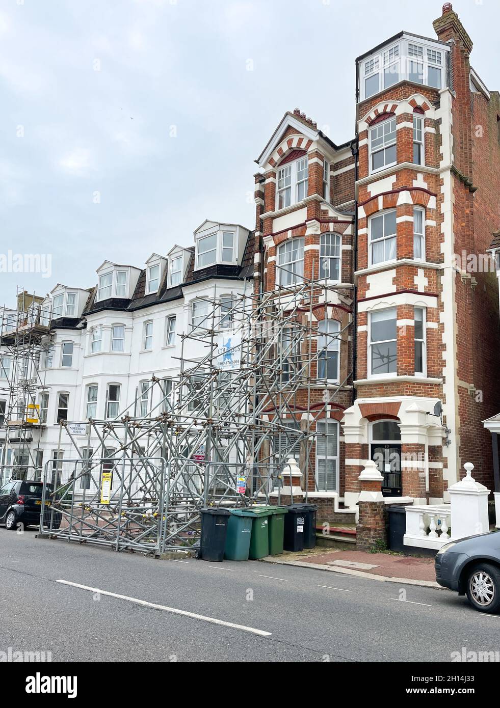 Un vecchio edificio terrazzato è supportato drammaticamente da una grande quantità di ponteggi che si estendono su due piani e raggiungono il marciapiede e la strada Foto Stock
