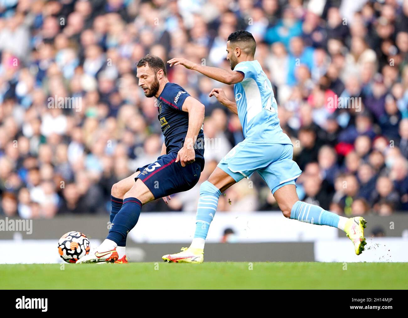 Erik Pieters di Burnley (a sinistra) e Riyad Mahrez di Manchester City combattono per la palla durante la partita della Premier League all'Etihad Stadium di Manchester. Data foto: Sabato 16 ottobre 2021. Foto Stock